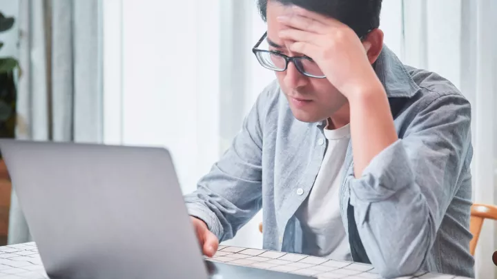 Man at computer. Looks frustrated.