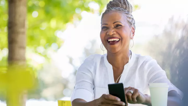 Older woman smiling holding her phone