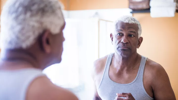 picture of man looking at himself in a mirror