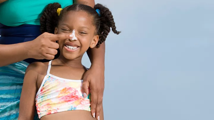 picture of a woman applying sunscreen to a child