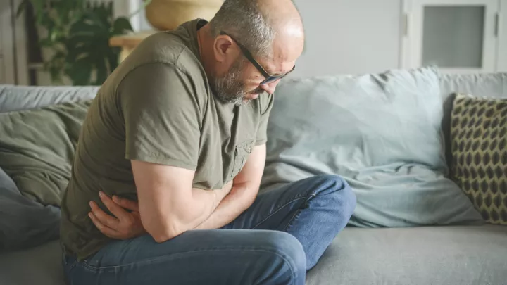 Man in pain holding stomach