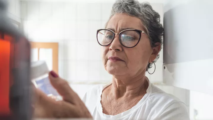 Older woman holding a pill bottle