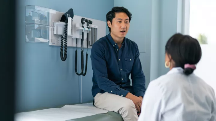 Man in doctor's office speaking to doctor