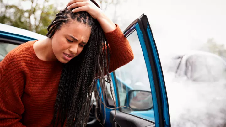 woman holding head after car crash