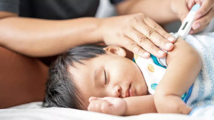 picture of an infant getting their temperature checked