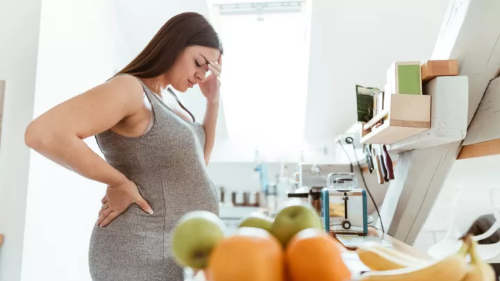 Sad pregnant woman in the kitchen