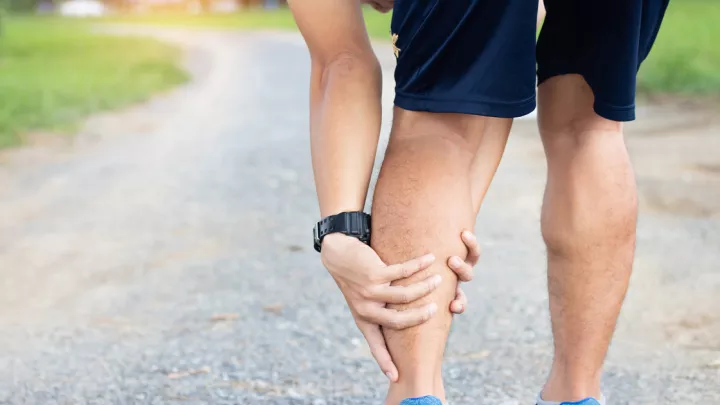 Close up of a man grabbing his calf