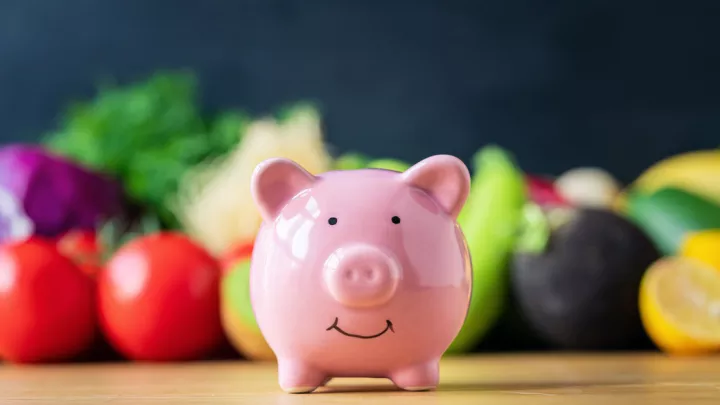 Piggy bank in front of fruits and vegetables