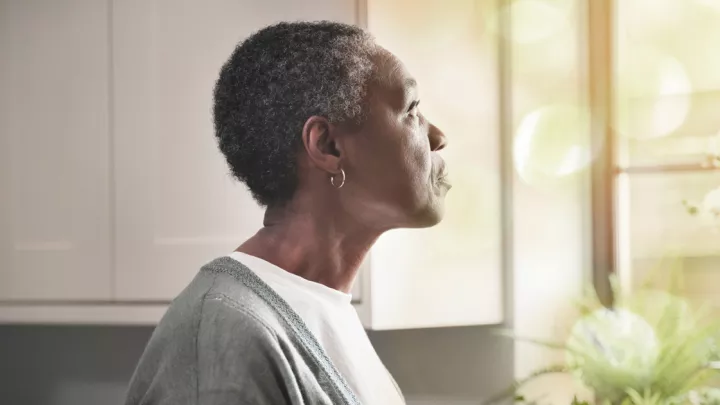 Older woman looking out a window