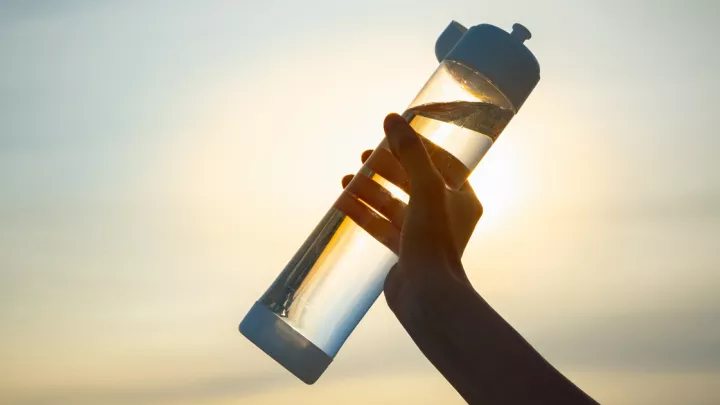 Close up of a hand holding a water bottle