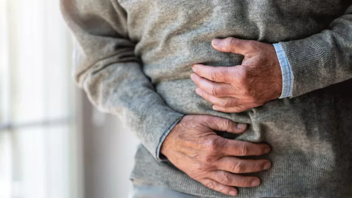 Close up of a man grabbing his stomach