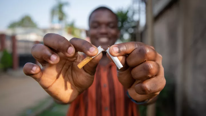 Man breaking a cigarette in half